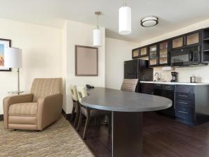 a kitchen with a table and chairs in a room at Candlewood Suites Enid, an IHG Hotel in Enid
