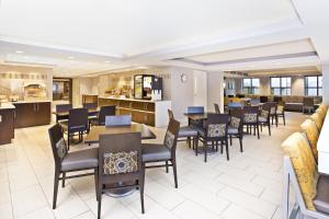 um restaurante com mesas e cadeiras e um bar em Holiday Inn Express Boston-Waltham, an IHG Hotel em Waltham