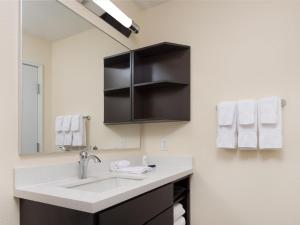 a bathroom with a sink and a mirror at Candlewood Suites Enid, an IHG Hotel in Enid