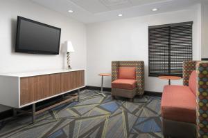 a waiting room with two chairs and a flat screen tv at Holiday Inn Express Washington DC-BW Parkway by IHG in Hyattsville +23 photos
