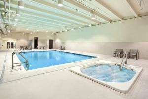 a large pool with a hot tub in a room at Holiday Inn Express - Sault Ste. Marie, an IHG Hotel in Sault Ste. Marie