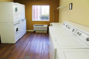 
a kitchen with white cabinets and white appliances at Candlewood Suites Washington-Dulles Herndon, an IHG Hotel in Herndon
