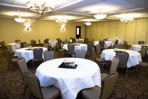 a banquet room with white tables and chairs and chandeliers at Holiday Inn Hotel & Suites Red Deer, an IHG Hotel in Red Deer