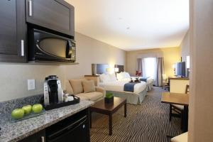 a hotel room with a bed and a living room at Holiday Inn Express Fort St John by IHG in Fort Saint John