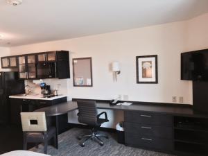 a hotel room with a desk and a sink at Candlewood Suites Youngstown W - I-80 Niles Area by IHG in Austintown +22 photos