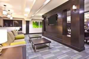 a living room with a couch and a tv at Holiday Inn Express - Sault Ste. Marie, an IHG Hotel in Sault Ste. Marie