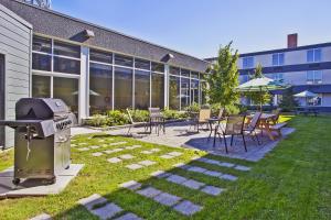 eine Terrasse mit einem Grill sowie Tischen und Stühlen in der Unterkunft Holiday Inn Express - Sault Ste. Marie, an IHG Hotel in Sault Ste. Marie