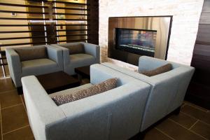 a living room with two chairs and a fireplace at Holiday Inn Hotel & Suites Red Deer, an IHG Hotel in Red Deer