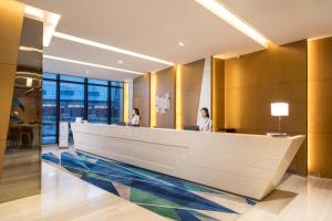 two women standing at a reception desk in a lobby at Holiday Inn Express Wuxi Taihu New City, an IHG Hotel in Wuxi