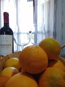 una cesta de naranjas y dos copas de vino en Cinque C, en Catania