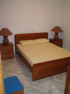 a bedroom with a bed and two nightstands with lamps at Villa Lagosta in Város