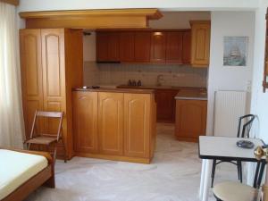 uma cozinha com armários de madeira, uma mesa e uma cama em Villa Lagosta em Város