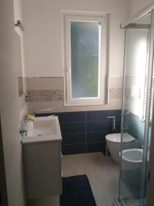 a bathroom with a sink and a toilet and a window at B&B TRA CIELO e MARE in Pietra Ligure