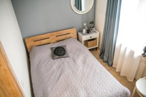ein Schlafzimmer mit einem Bett mit einem Kopfteil aus Holz in der Unterkunft Downtown Apartment Rentals in Šiauliai
