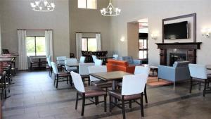 a restaurant with tables and chairs and a fireplace at Holiday Inn Express Hotels & Suites Rockingham West by IHG in Rockingham