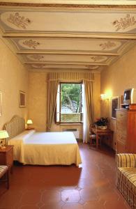 Un dormitorio con una cama grande y una ventana en B&B Palazzo Al Torrione 2, en San Gimignano