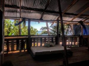 a bed on a porch with a view of the ocean at Surfhost in Garza