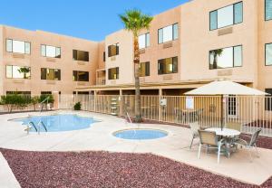 a building with a pool and a table and chairs at Holiday Inn Express Hotel & Suites Nogales, an IHG Hotel in Nogales