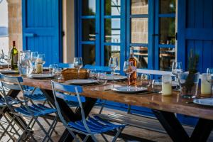 a long wooden table with chairs and wine glasses at Villa Amarina in Trogir