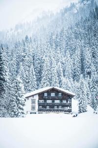 een gebouw voor een met sneeuw bedekte berg bij Alpenhotel Heimspitze in Gargellen