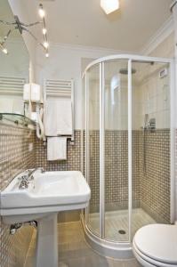 uma casa de banho com um chuveiro, um lavatório e um WC. em B&b Querini em Roma