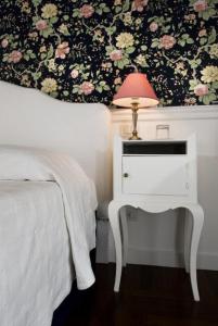 um quarto com uma cama e uma mesa com um candeeiro em B&b Querini em Roma