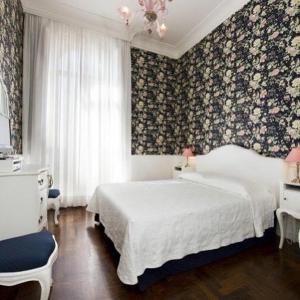 um quarto com uma cama branca e uma parede floral em B&b Querini em Roma
