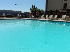 a large blue swimming pool with chairs in a building at Holiday Inn Express Harrisburg SW - Mechanicsburg, an IHG Hotel in Mechanicsburg