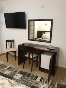 a desk with a mirror and a chair in a room at Casa Pino in Braşov