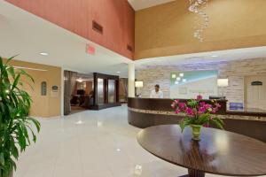 a lobby with a table with flowers on it at Armoni Inn & Suites in Orangeburg