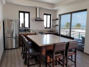 a kitchen with a table and chairs and a kitchen with the ocean at Blu Zen in Caye Caulker