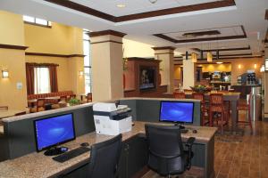 パデューカにあるHoliday Inn Express & Suites Paducah West, an IHG Hotelのデスクにコンピュータモニターが2台ある事務所