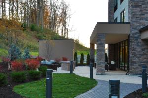 a building with a courtyard with tables and chairs at Holiday Inn Express Oneonta, an IHG Hotel in Oneonta