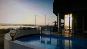 a swimming pool with a view of the ocean at Sunset 786 Holidays 211 in Strand