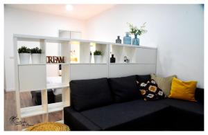 a living room with a black couch and white shelves at Cantinho do Piano in Velas