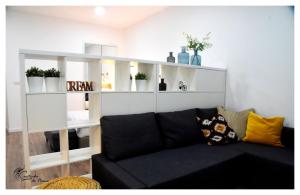 維拉斯的住宿－Cantinho do Piano，客厅配有黑色沙发和白色架子