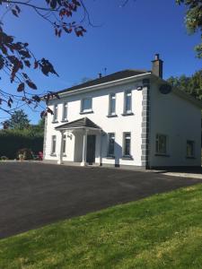 una casa blanca con una entrada delante de ella en Laurel lodge en Killarney