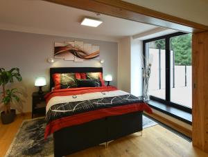 sypialnia z łóżkiem i dużym oknem w obiekcie Luxury Apartments Adelka w Szpindlerowym Młynie