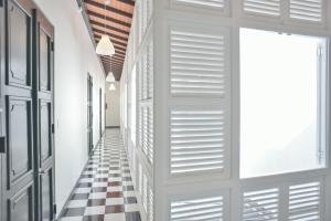 a hallway with a checkered floor and a door at Fortel Hostel in San Juan