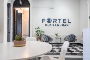 una sala riunioni con tavolo e sedie bianchi di Fortel Hostel a San Juan