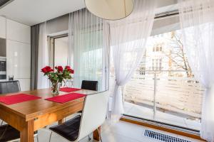 a dining room with a wooden table and a window at Apartament Playa Baltis 10 in Międzyzdroje