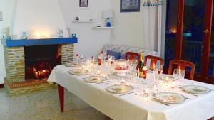 a table with a white table cloth and a fireplace at villa Terre Brûlée in Ceyreste