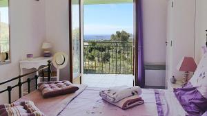 a bedroom with a bed with a view of a balcony at villa Terre Brûlée in Ceyreste +18 photos