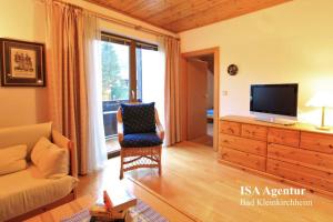 a living room with a couch and a tv and a chair at Apartment KATHREIN ski & spa in Bad Kleinkirchheim