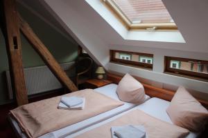 a attic bedroom with two beds and a skylight at La Rustica Altstadthotel in Wernigerode