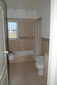 uma casa de banho com um WC, uma banheira e um lavatório. em Ayuntunhue Apart Hotel em San Bernardo