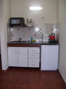 uma pequena cozinha com um lavatório e um micro-ondas em Ayuntunhue Apart Hotel em San Bernardo