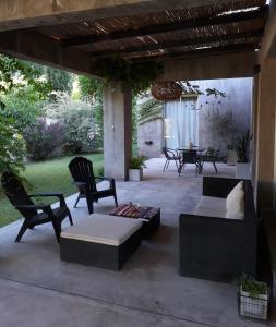 un patio con sofá, sillas y mesa en Casa Los Cerezos en Chacras de Coria en Chacras de Coria