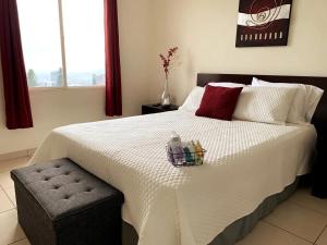 Un dormitorio con una cama blanca con una cesta. en Beautiful apartment, Terrace with incredible view, 3 bdr, Escalon, Exclusive, Secure, en San Salvador