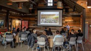 un gruppo di persone seduti ai tavoli in una stanza con presentazione di The Headwaters Eco Lodge a Glenorchy